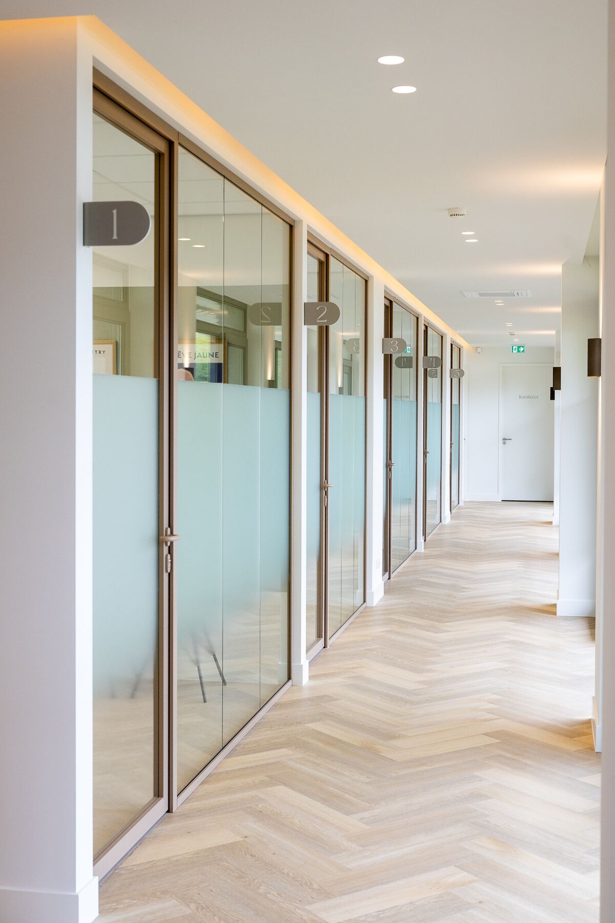 Corridor met glazen behandelkamers en maatwerk kamernummers